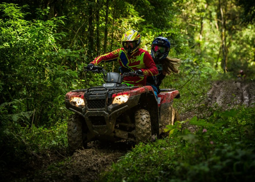 man and woman riding on ATV